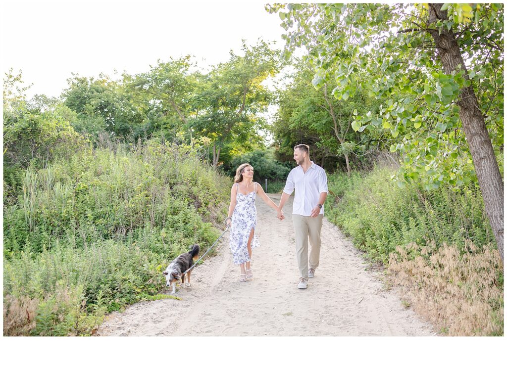 Engaged couple walking with dog 
