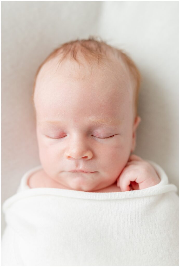 New Jersey lifestyle newborn photo of baby boy wrapped in white with soft natural light